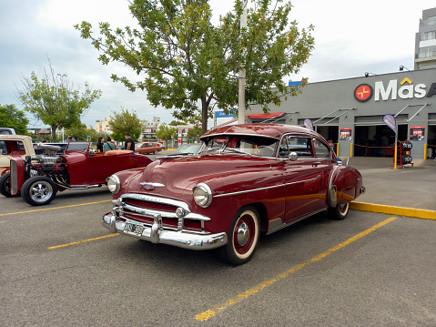 Buenos Aires, Argentina - Feb 25, 2024: Old red shiny 1949 Chevrolet Styleline two door sedan at a classic car show in a parking lot.
