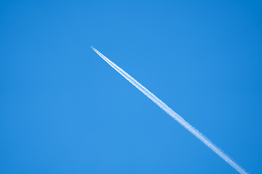 a plane with a smoke trail flies high in the sky without clouds, transport, travel