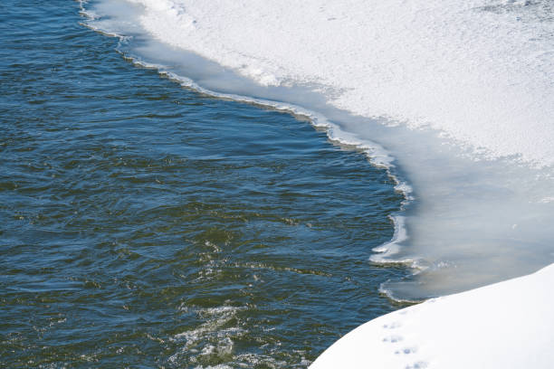 istock spring landscape with a river under ice and snowdrifts on the shore, March 2056498314