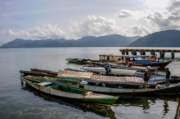 Kolonodale, Central Sulawesi - oct 24,2009: boarding operations on a long motor canoe departing for an exploration at the Morowali Nature Reserve, from the pier in Kolonodale, Sulawesi