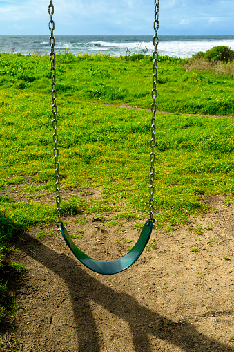 Close-up of playground swing on an empty oceanside playground.

Taken in Davenport, California, USA