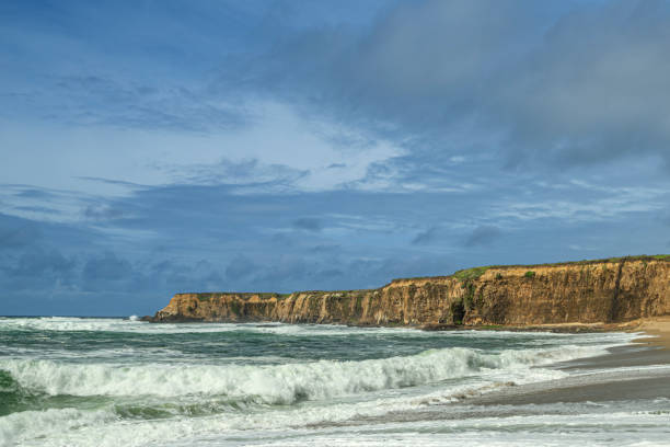 Turbulent ocean waves breaking along the Pacific coast under a cloudy sky, as a storm passes through the area.Taken in Davenport, California, USA