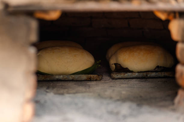 Homemade breads baking in a rustic wood-fired oven. The image portrays the artisanal and traditional way of making homemade bread in the Brazilian countryside
