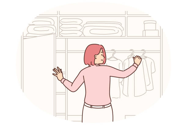 istock Woman stands with back to screen near large wardrobe closet choosing outfit for going to work 2056556084