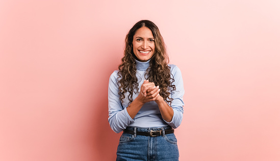 Pink background of a happy hispanic woman smiling at the camera