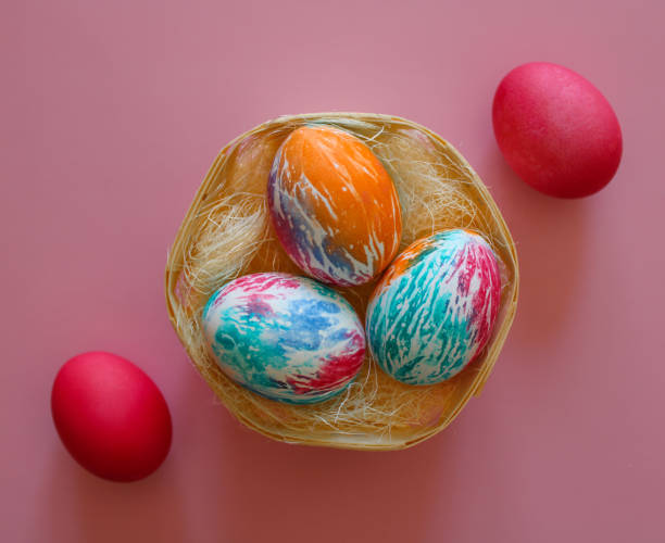 istock Happy Easter holiday! Colorful hand-painted Easter eggs in a decorative nest on pink background. Preparing for the celebration of Easter. 2056593434