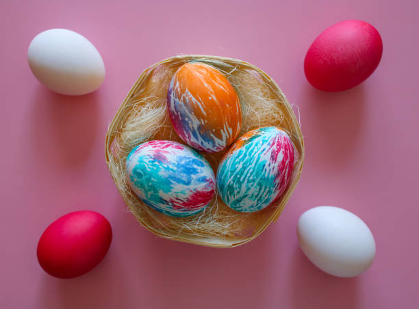 istock Happy Easter holiday! Colorful hand-painted Easter eggs in a decorative nest on pink background. Preparing for the celebration of Easter. 2056594007