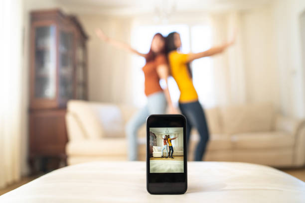 istock Two young women dancing in front of a camera phone 2056740021