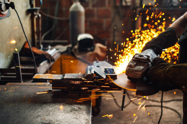 istock Working in a metal workshop while grinding a big piece of metal plate. 2056751478