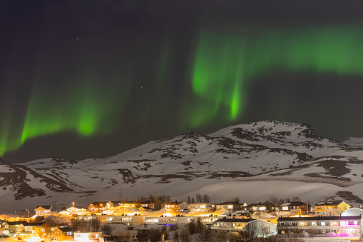 Aurora borealis (Northern Lights) on cloudy sky.
Hammerfest - Norway.
