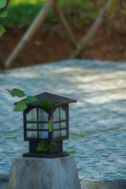 a vertical shot of a wooden lantern in the garden