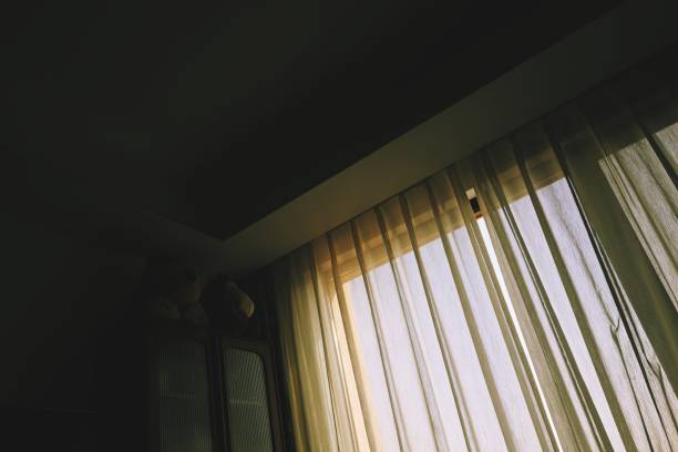 istock Room with curtains drawn, sunshine outside the window, darkness inside the room 2056863751