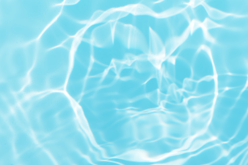 Waves on the beach. Blue sea wave. Blue water surface texture with ripples, splashes, and bubbles. Abstract summer banner background Water waves in sunlight with copy space cosmetic moisturizer.