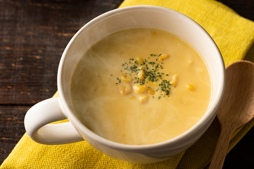 Warm potage soup with plenty of corn and steaming hot.