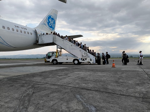 Banda Aceh, Aceh, Indonesia - February 29, 2024: It appears that airplane passengers are waiting in line to board the plane via the back stairs