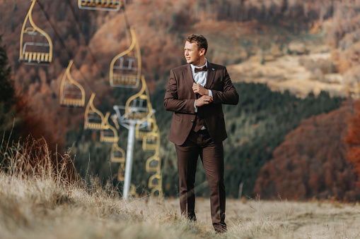 Young man on the hill of a mountain. Businessman. Bridegroom. Groom. Aerial