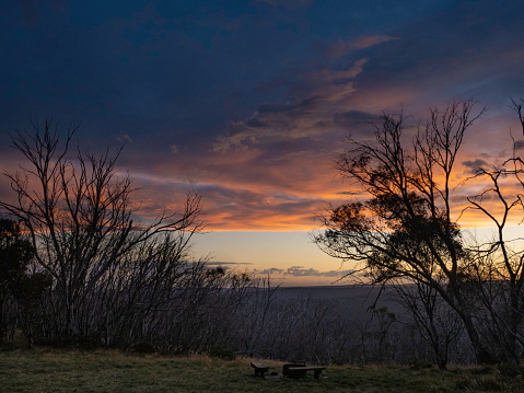 Dramatic sunset at Falls Creek with dead burnt trees in silhouette