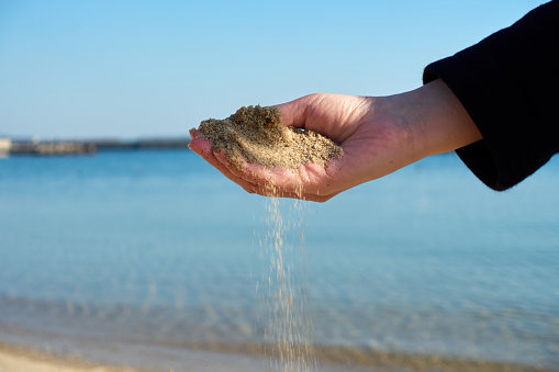 sand falling from hands.