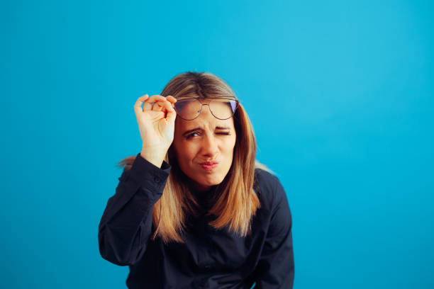 Woman taking Off her Eyeglasses and Squinting