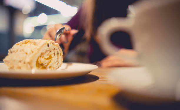 istock Savoring a Decadent Layered Cream Cake at a Cozy Evening Cafe, using a fork to delicately take a bite. 2056981128