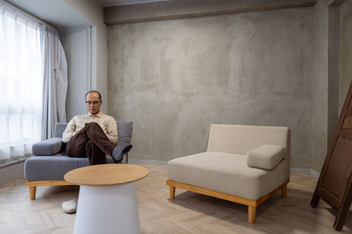 Man relaxing in living room, using smart phone