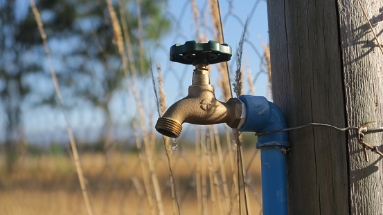 Dripping water faucet with pipe in a rural area