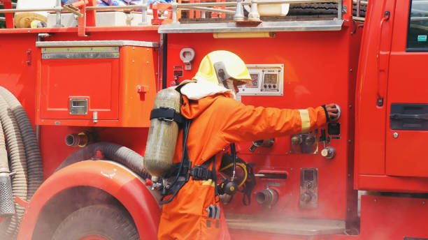 istock Fireman prepare equipment fighting extinguisher at fire engine truck. Firefighter fighting with smoke flame using fire hose, tube, chemical water foam spray at truck. Fireman wear hard hat protection 2056993069
