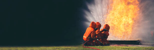 istock Firefighter Rescue training in fire fighting extinguisher. Firefighter fighting with flame using fire hose chemical water foam spray engine. Fireman wear hard hat, safety suit uniform for protection 2056994156