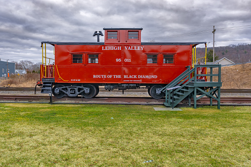 Sayre, PA, USA - 03-03-2024 - Restored red vintage caboose at the Sayre Historical Society Museum at Lehigh Valley Railroad Passenger Station.