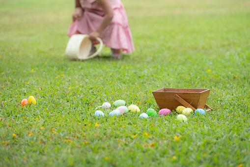 Girl enjoying outdoor activities in the park including a run to collect beautiful Easter eggs.