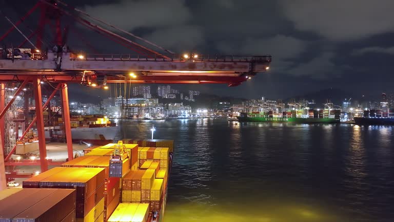 Aerial View of Container Terminal at Night with Cranes and Cargo.