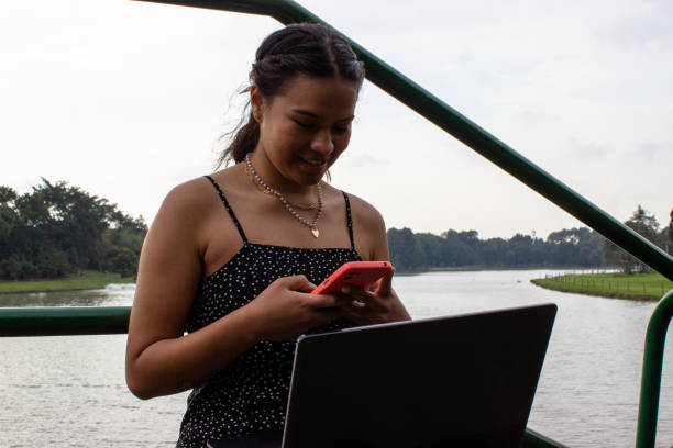 istock Beautiful young woman doing remote work outside 2057090372