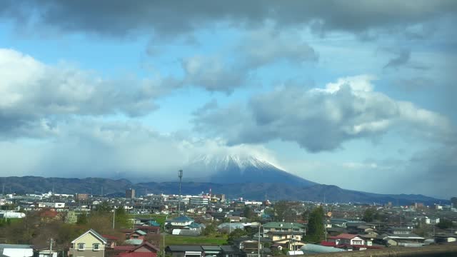 View of Mount Iwaki through the window of a moving train.