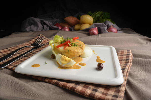 boiled egg with potato salad and dressing in square plate appetiser on brown cloth table western restaurant Peruvian cuisine cafe halal menu