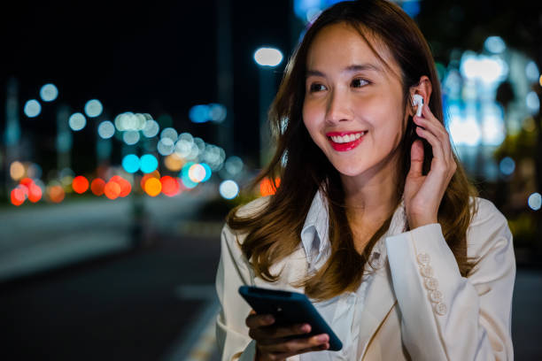 istock Woman using mobile phone in city during night 2057138619