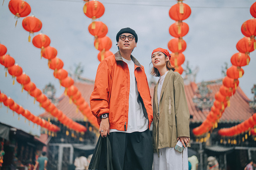 portrait of Asian Chinese couple tourist standing in front of Chinese Temple during Chinese New Year Chap Goh Mei