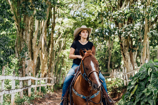 Cowgirl on the way in wooded area