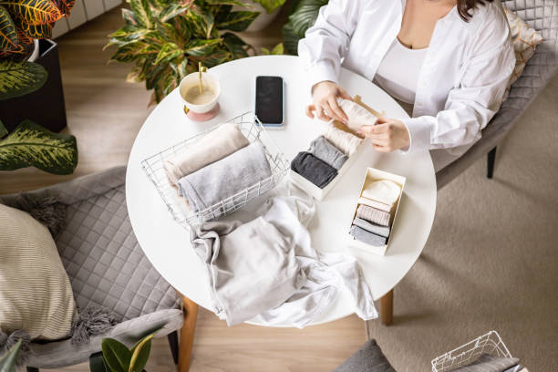 istock Unrecognizable woman sorting neatly folded linen cotton textile at container and basket on table 2057169213