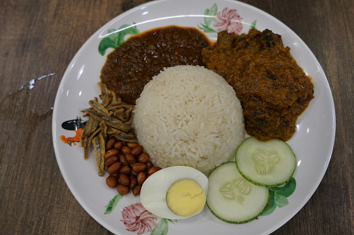 Nasi lemak, a Malay style complete meal of fragrant rice dish cooked in coconut milk.  It is served together with omelette, fried ground nuts, fried anchovies, cucumber and spicy chili sauce (sambal).