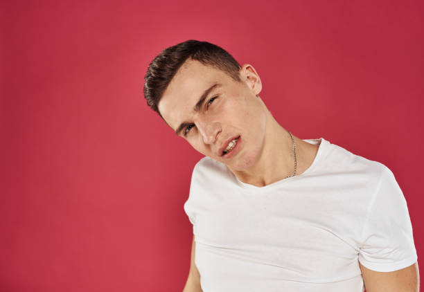 istock emotional man in white t-shirt studio dissatisfaction red background 2057214590