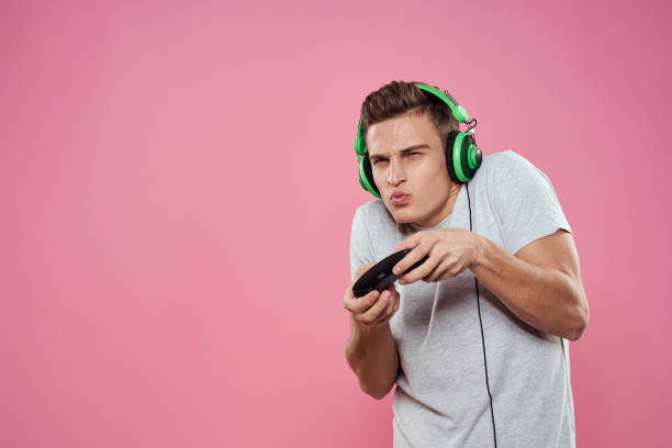 istock man wearing white t-shirt console joystick games craze technology pink background 2057232439