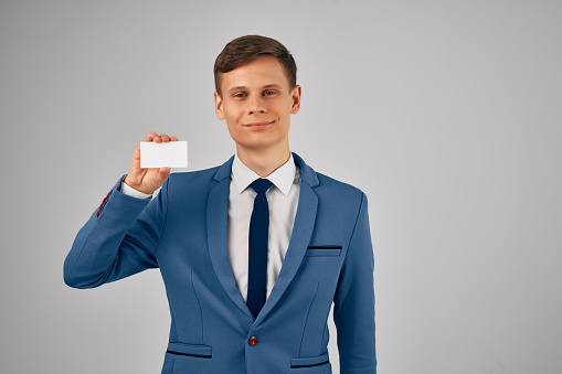 business man in a suit holding a business card copy space advertisement. High quality photo