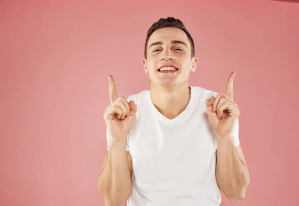 istock happy guy gesturing with his hands and showing fingers to the side emotions model 2057333686