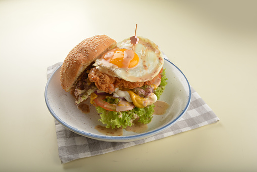 chef handmade giant deep fried crispy chicken with fried egg and vegetables cheesy burger in japanese sesame sauce restaurant western fast food cafe halal menu