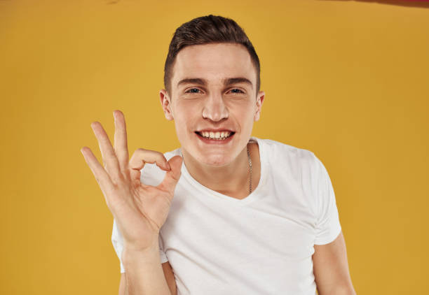 istock Man shows positive gestures with his hands fun yellow background cropped view 2057340046