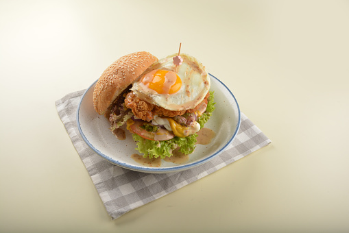 chef handmade giant deep fried crispy chicken with fried egg and vegetables cheesy burger in japanese sesame sauce restaurant western fast food cafe halal menu