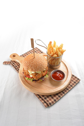 chef handmade deep fried crispy chicken tempura prawn cheesy ramly burger with French fries and sauce in plate restaurant western fast food cafe halal menu