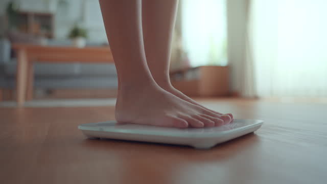 B roll - Woman Feet Standing Weighing Scales, Female Checking BMI Weight Loss. Barefoot Measuring Body Fat Overweight