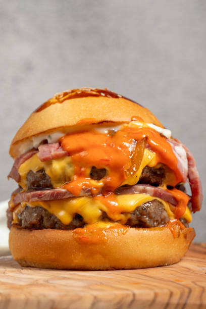 istock Double Hamburger. With Cheddar cheese, caramelized onions, Roast beef and special sauce. Hamburger with two meatballs on serving board. Close up 2057385803