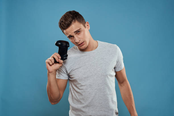 istock A man with a joystick in his hands entertainment leisure technology video games blue background white t-shirt 2057388450